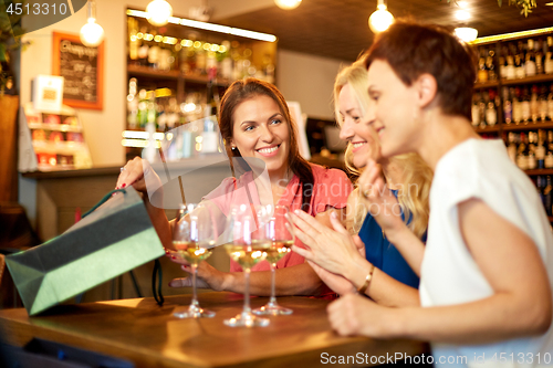 Image of women with shopping bags at wine bar or restaurant