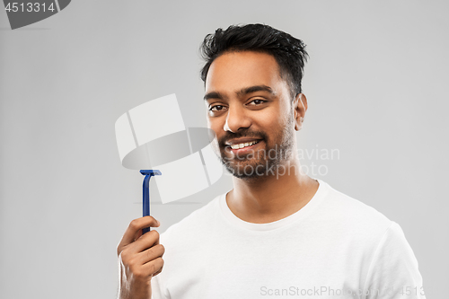 Image of indian man shaving beard with razor blade