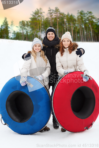 Image of happy friends with snow tubes outdoors in winter
