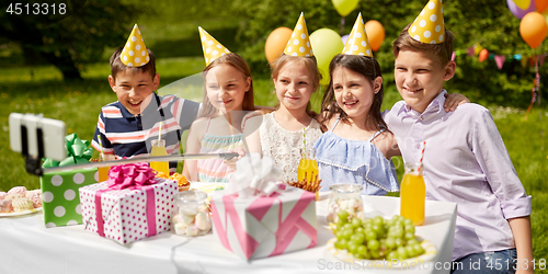 Image of happy kids taking selfie on birthday party