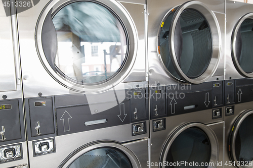 Image of washing machines with clothes inside at laundromat