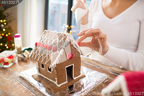 Image of close up of woman making gingerbread house