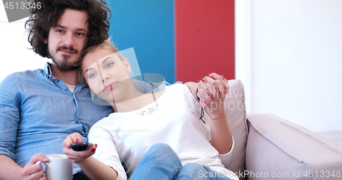 Image of Young couple on the sofa watching television