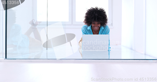 Image of black women using laptop computer on the floor
