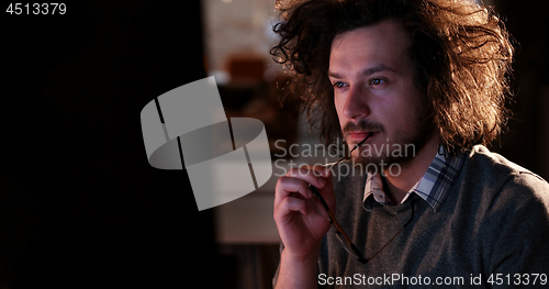 Image of man working on computer in dark office