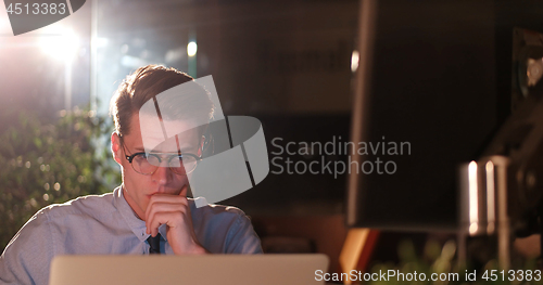 Image of man working on computer in dark office