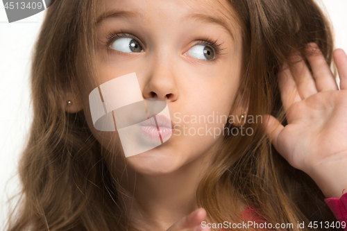 Image of The young teen girl whispering a secret behind her hand over white background