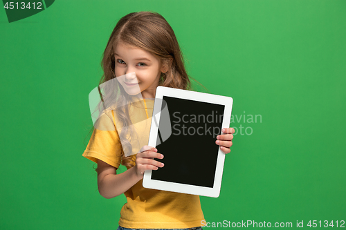 Image of Little funny girl with tablet on green background