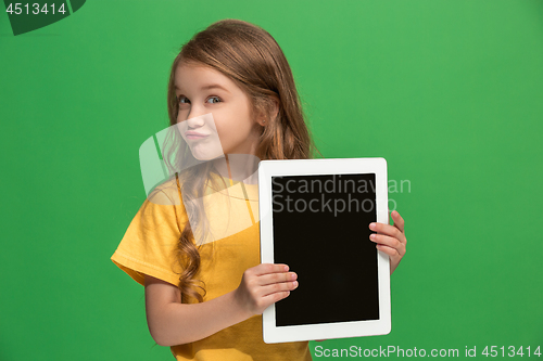Image of Little funny girl with tablet on green background