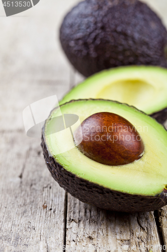 Image of Avocado on old wooden table background. Fresh avocado halves on 