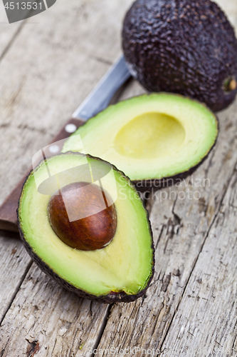 Image of Fresh organic avocado and knife on old wooden table background. 