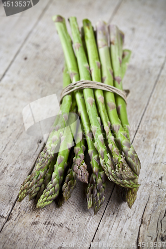 Image of Bunch of fresh raw garden asparagus on rustic wooden table backg