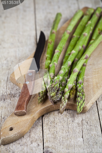 Image of Fresh raw garden asparagus and knife closeup on cutting board on