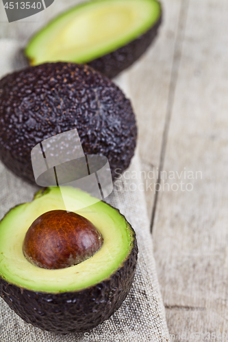 Image of Organic avocado on linen napkin on rustic wooden table backgroun