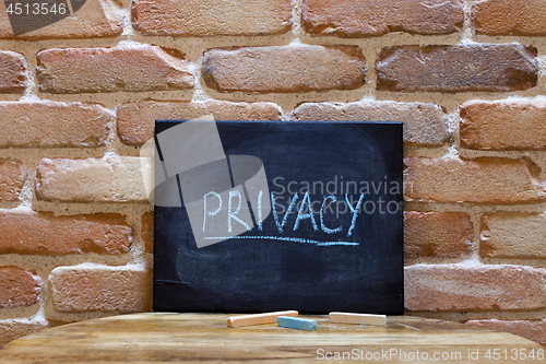 Image of Black board with the word "Privacy" drown by hand on wooden tabl