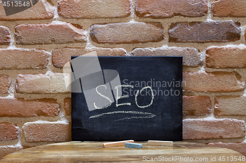 Image of Black board with the word SEO drown by hand on wooden table on b