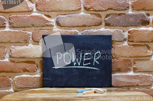 Image of Chalk board with the word "Power" drown by hand on wooden table 