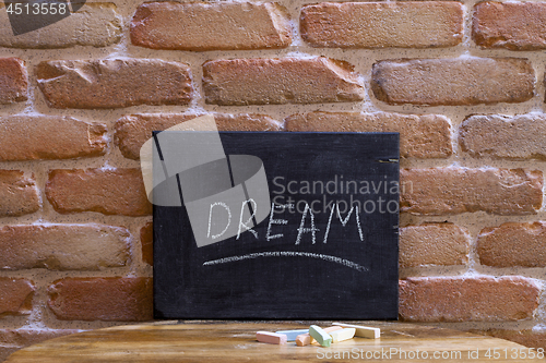 Image of Black board with the word DREAM drown by hand on wooden table on