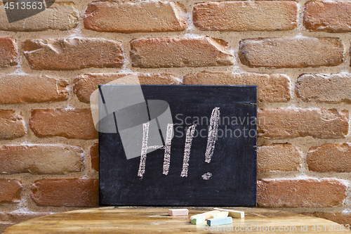 Image of Black board with the word HI! drown by hand on wooden table on b