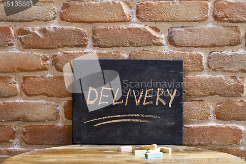 Image of Chalk board with the word DELIVERY drown by hand on wooden table