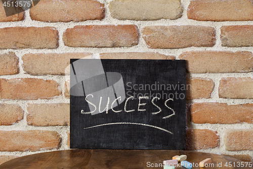 Image of Chalk board with the word SUCCESS drown by hand on wooden table 