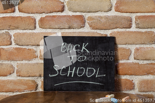 Image of Black chalkboard with the phrase BACK TO SCHOOL drown by hand on