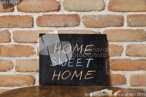 Image of Black chalkboard with the phrase HOME SWEET HOME drown by hand o