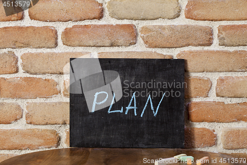 Image of Chalk board with the word PLAN drown by hand on wooden table on 