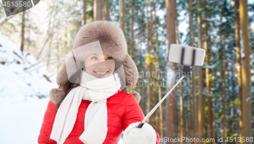 Image of happy woman taking selfie over winter forest