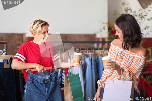 Image of happy women with coffee at vintage clothing store