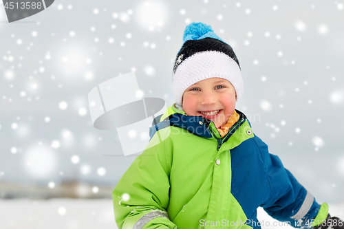 Image of happy little boy in winter clothes outdoors