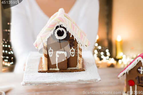 Image of close up of woman with christmas gingerbread house