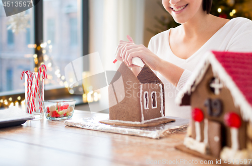Image of woman making gingerbread houses on christmas