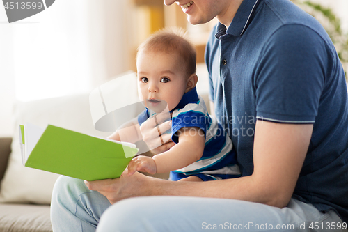 Image of baby boy and father with book at home