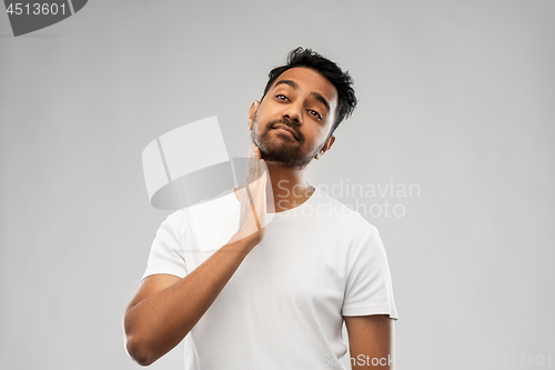 Image of indian man touching his beard