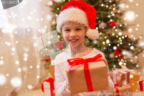 Image of smiling girl in santa hat with christmas gift