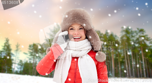 Image of woman calling on smartphone over winter forest