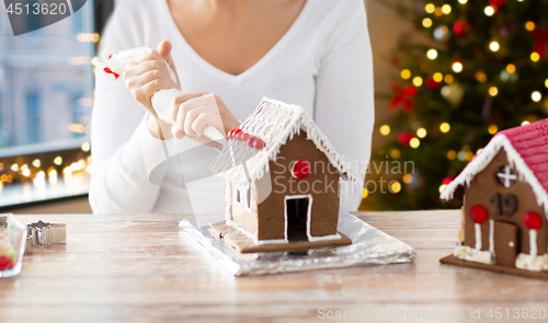 Image of woman making gingerbread houses on christmas