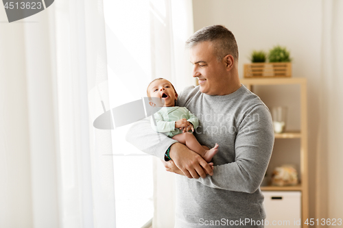 Image of happy father holding with little baby son at home