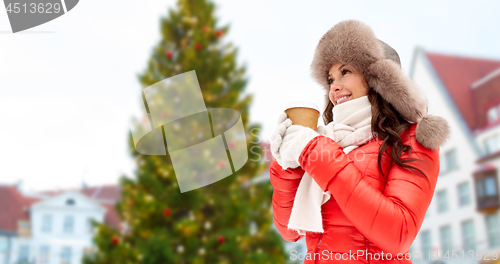 Image of woman with coffee over christmas tree in tallinn