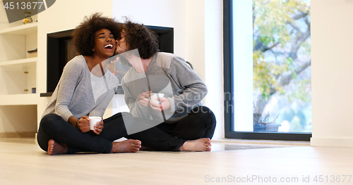 Image of multiethnic couple  in front of fireplace