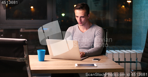 Image of man working on laptop in dark office