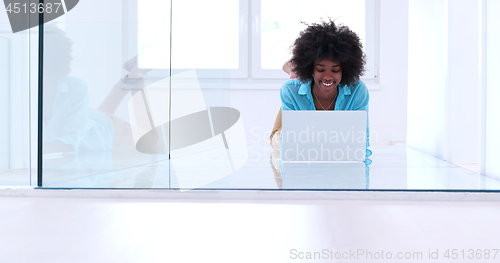 Image of black women using laptop computer on the floor