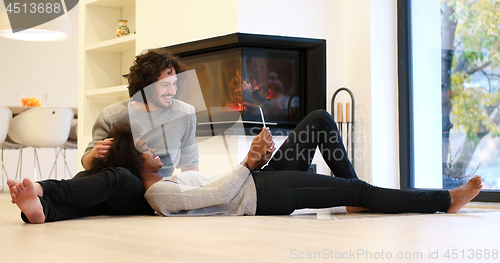 Image of Young Couple using digital tablet on the floor