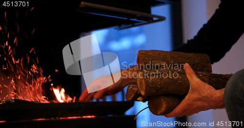 Image of hands at fireplace making fire