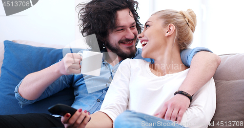 Image of Young couple on the sofa watching television