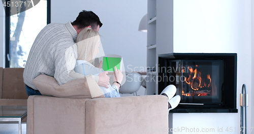 Image of couple relaxing at  home with tablet computers