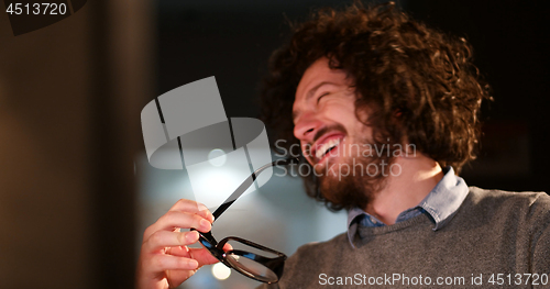 Image of man working on computer in dark office