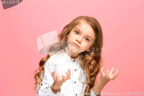 Image of Portrait of angry teen girl on a pink studio background