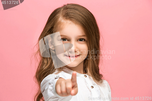 Image of The happy teen girl standing and smiling against pink background.